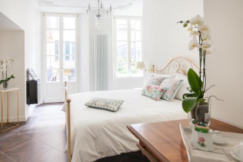 a white bedroom with a bed and a table at Alessia's Place in Como