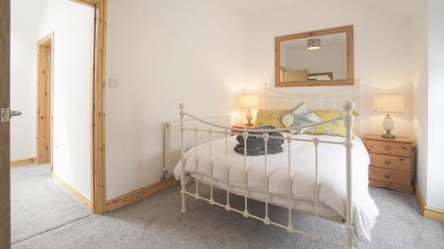 a bedroom with a bed with a mirror on the wall at Glanafon Cottage in Bethesda