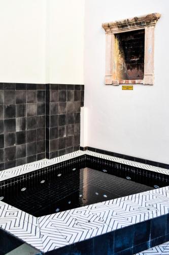 a bathroom with a black and white tiled floor at Central Hotel Boutique in Chihuahua