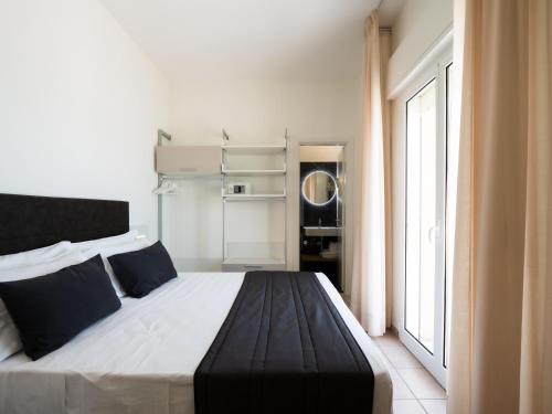 sypialnia z dużym łóżkiem i dużym oknem w obiekcie Hotel Florence w mieście Marotta