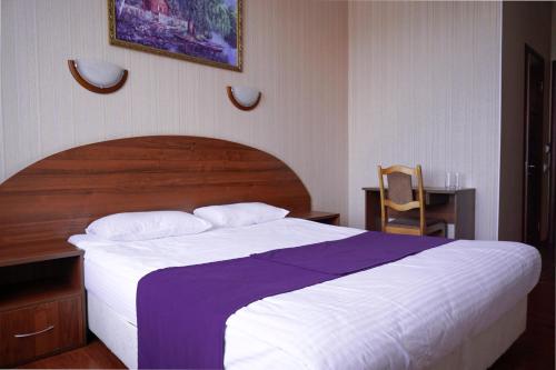 ein Schlafzimmer mit einem großen Bett mit einer lila Decke in der Unterkunft Hantri Hotel in Sergijew Possad