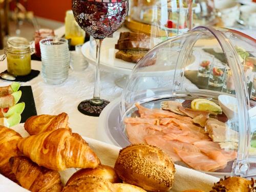 a table with a plate of food and a glass of wine at Das Landhaus in Prüm