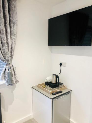 a tv on a wall with a tea kettle on a table at Oxford Studios in Kidlington