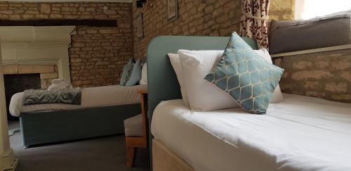 a bedroom with a bed with a blue pillow on it at The Kings Arms Hotel in Stow on the Wold
