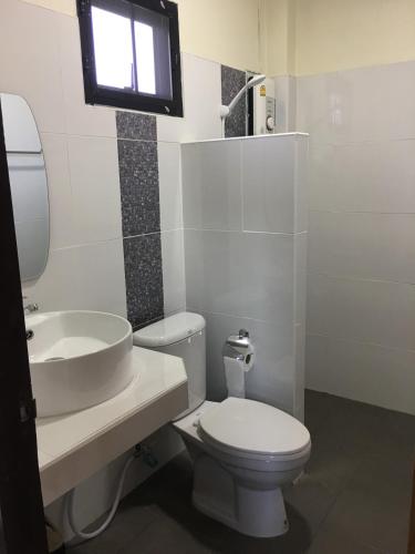 a bathroom with a toilet and a sink and a window at บ้านมาดีโฮมสเตย์ in Ban Huai La