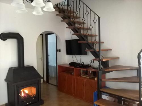 a living room with a wood stove and a staircase at ZENITH APARTMAN in Gárdony