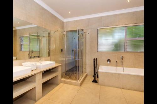 y baño con 2 lavabos, ducha y bañera. en 6 On Acacia, en Johannesburgo