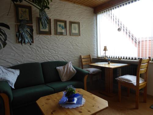 阿爾戈伊地區伊斯尼的住宿－Ferienwohnung Kullmann-Arendt，客厅配有绿色沙发和桌子