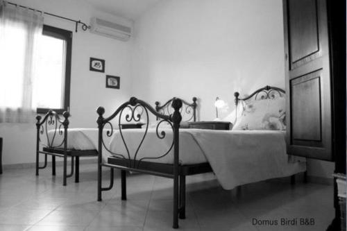 a bedroom with two beds and a window at Domus Birdi in Orroli