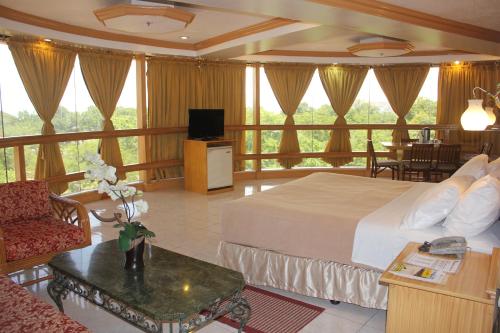 een hotelkamer met een bed en een woonkamer bij Elegant Circle Inn in Cebu City