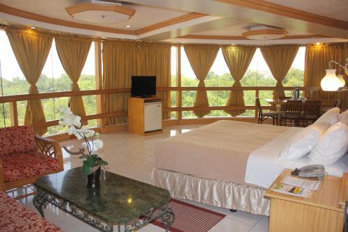 a hotel room with a bed and a living room at Elegant Circle Inn in Cebu City