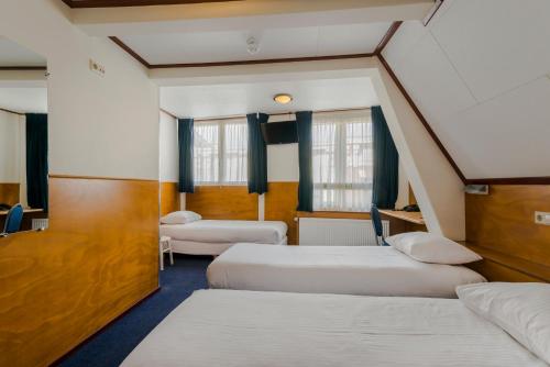a room with two beds and two windows at Hotel van Gelder in Amsterdam