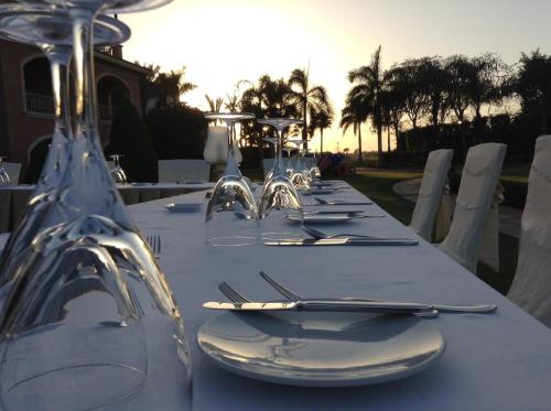 a long table with white plates and silverware on it at Stella Golf Hotel in Ain Sokhna