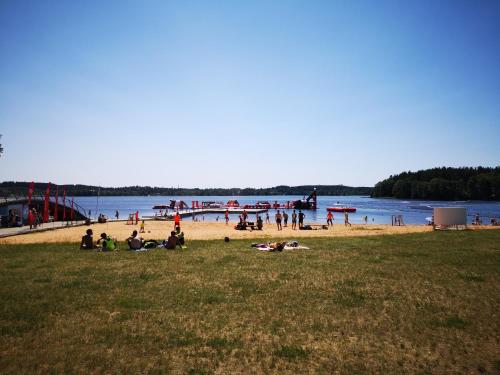 a group of people sitting on a beach near the water at Griežto 5 in Zarasai