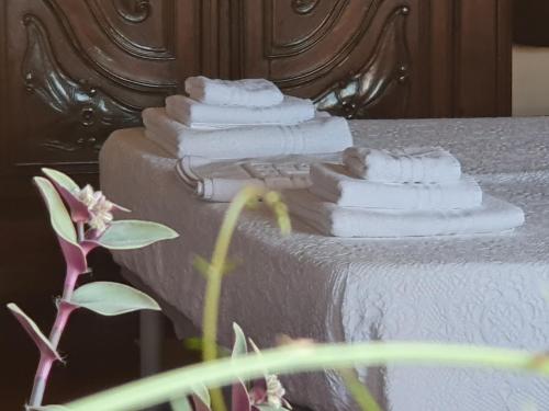 een stapel gevouwen handdoeken zittend op een bed bij Palatina apartment in Turijn