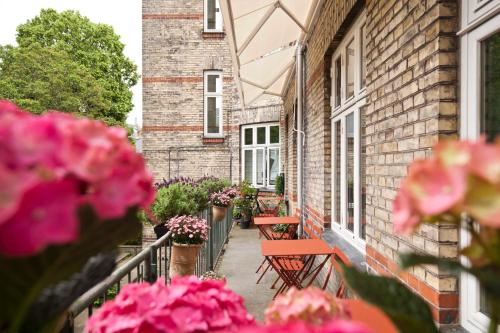 einen Balkon mit Bänken und Blumen auf einem Gebäude in der Unterkunft Rye115 Hotel in Kopenhagen