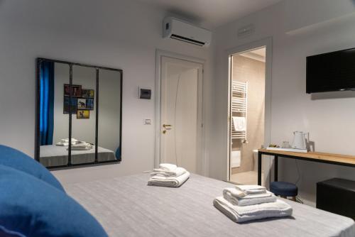 a bedroom with towels on a bed with a mirror at Me&Sea B&B in San Nicola Arcella