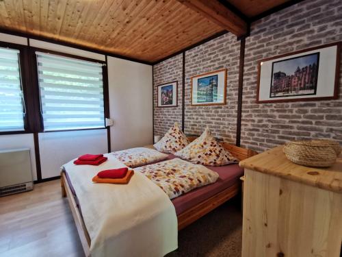 a bedroom with a bed and a brick wall at Ferienhaus Rhode am Alfsee in Rieste
