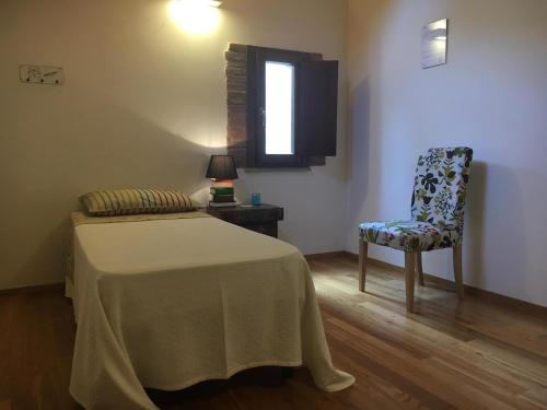 a bedroom with a bed and a chair and a window at Al Libro Letto in Viterbo