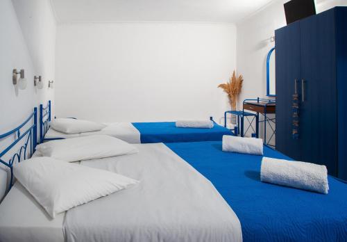 a bedroom with a blue bed and blue walls at Roula Villa Studios & Apartments in Perissa