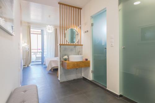 y baño con lavabo y espejo. en Rotunda Suites en Kalamaki Chanion