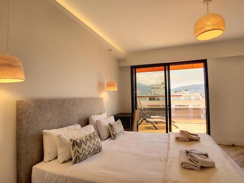 une chambre avec un grand lit avec une grande fenêtre dans l'établissement Nestor&Jeeves - SKY LIGHT TERRACE - Hyper center - By sea - Top floor, à Nice