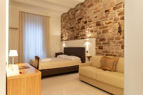 a bedroom with two beds and a brick wall at Portica10 in Assisi