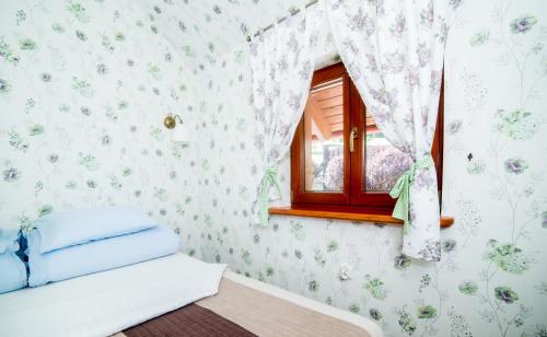 ein Schlafzimmer mit Blumentapete und einem Fenster in der Unterkunft Apartamenty Romanowka in Raszów