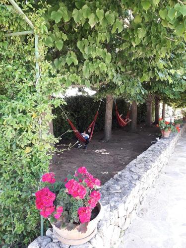 a person sitting in a hammock in a hammockukongukongukongukongukong at Villa Minerva Family Relais in Alezio
