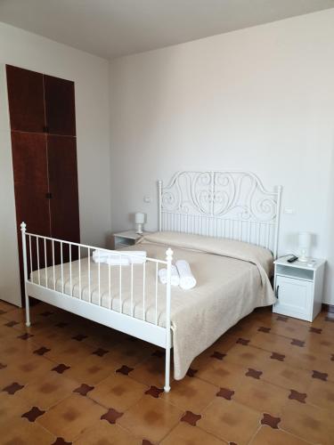 a bedroom with a white bed and a wooden floor at Casa Nostra Villa Cellini in Villaggio Mosè