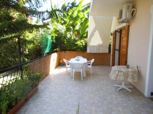 a patio with a table and chairs and a fence at Villa Xenos in Kalamaki