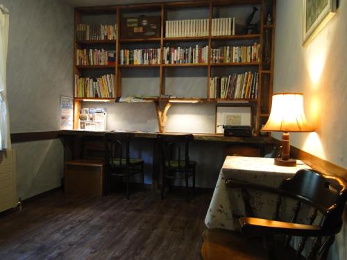 a library with a desk with chairs and a lamp at ノマの森 Nomanomori B&B in Chino