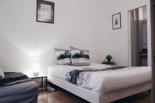 - une chambre avec un lit doté de draps et d'oreillers blancs dans l'établissement Levis Charming Place, à Paris