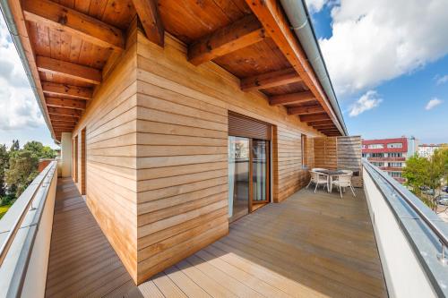 a balcony with wood paneling on a building at Wczasowa, Sun & Snow in Ustka