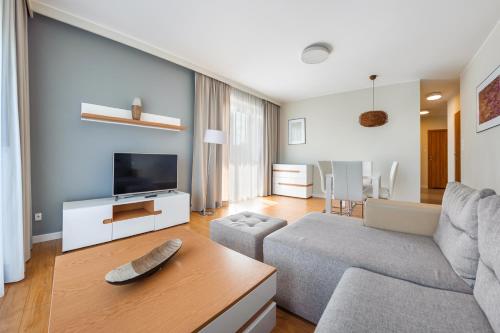 a living room with a couch and a tv at Wczasowa, Sun & Snow in Ustka