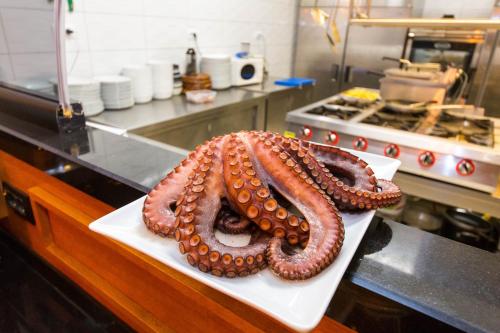 an octopus sitting on a plate in a kitchen at Hotel Sole Mare in Ksamil