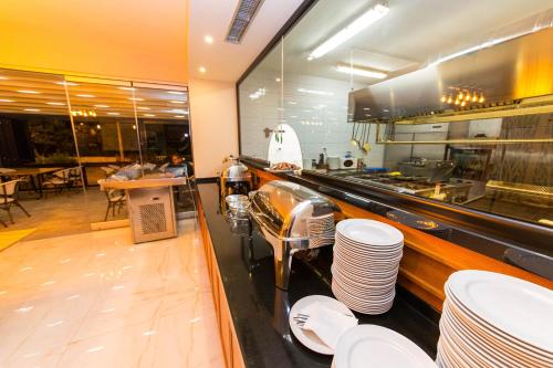 a restaurant with a counter with stacks of plates at Hotel Sole Mare in Ksamil