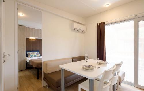 a white table and chairs in a room with a bed at Camping Village Roma Capitol in Ostia Antica
