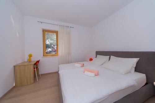 a bedroom with a large white bed and a table at A&J deluxe apartment in Biograd na Moru