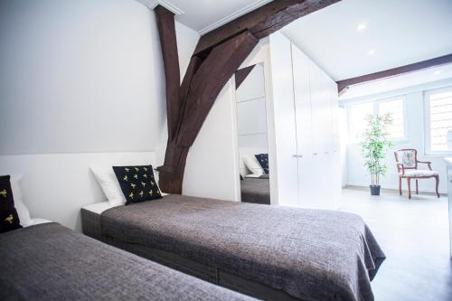 a bedroom with two beds and a chair at Luxury Suites Cathedral by Rikas Hotels in Antwerp