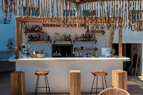 a bar in a room with stools at Bohemian Luxury Boutique Hotel, Adults Only in Naousa