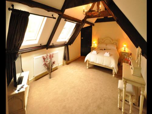 a bedroom with a bed and two windows and a piano at The Langley Arms Bed and Breakfast in Bristol