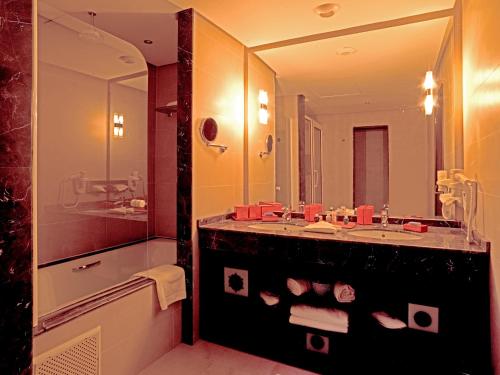 a bathroom with a sink and a large mirror at Palais Médina Riad Resort in Fès