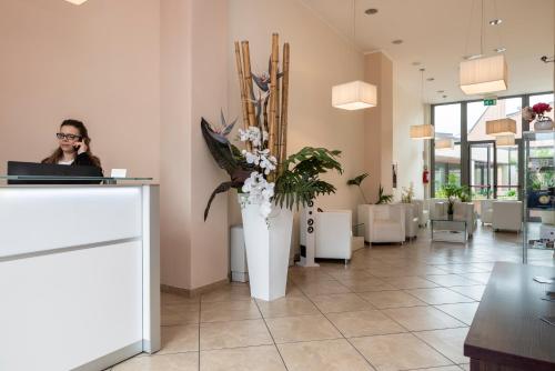 a woman talking on a phone in a lobby at ApartHotel Anghel in Siena