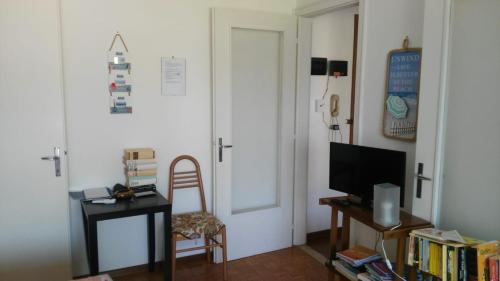 a room with a door and a chair and a television at Appartamento Perco Riva Dandolo in Grado