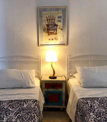 a bedroom with two beds and a lamp on a night stand at Hydra's View in Hydra