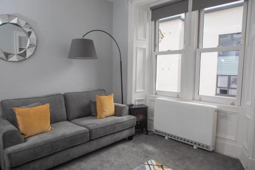 a living room with a couch and a window at The Old Post House in Kyle of Lochalsh