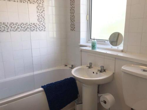 a bathroom with a sink and a toilet and a bath tub at Hooton Golf Club in Little Sutton