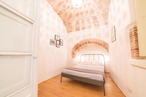 ein Schlafzimmer mit einem Bett in einem Zimmer mit einem Bogen in der Unterkunft Archi di Castello, Storia e Design 3Br-WiFi-AC in Cagliari