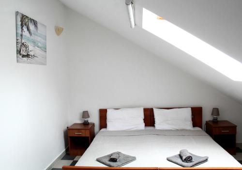 ein Schlafzimmer mit einem Bett mit zwei Hüten darauf in der Unterkunft Darina HN in Herceg-Novi
